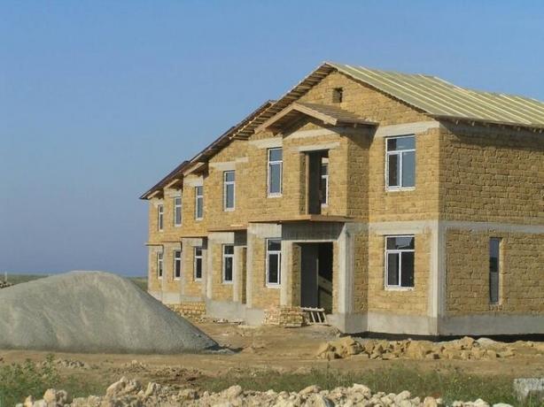 Fotografija - hiša z okvirjem in stene betona in zatrepi apnenca.